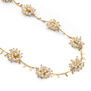 Detail of a necklace with clusters of white faux pearls.